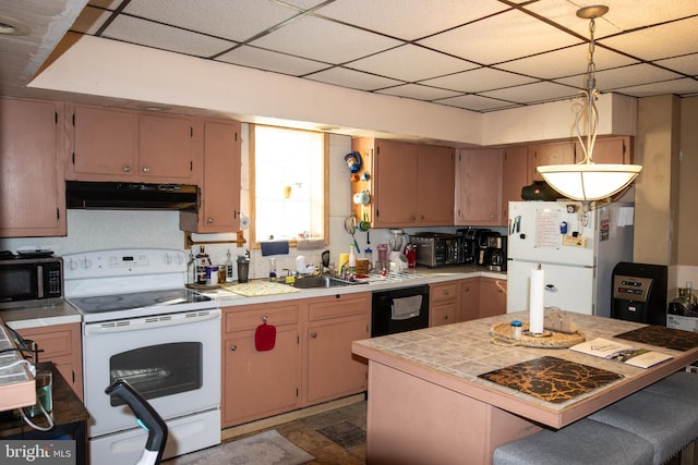 kitchen featuring pendant lighting, a drop ceiling, white appliances, and dark wood-type flooring