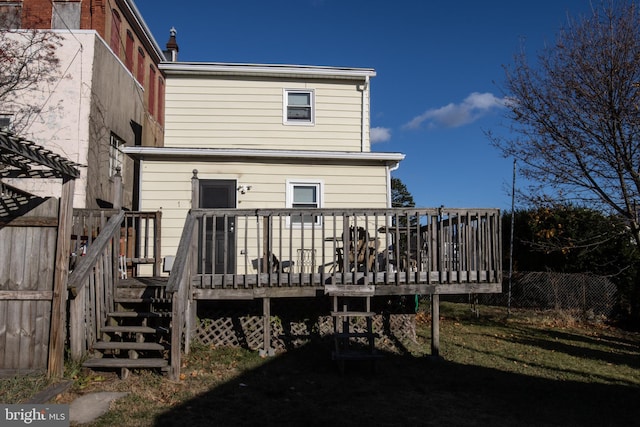 back of property with a yard and a deck