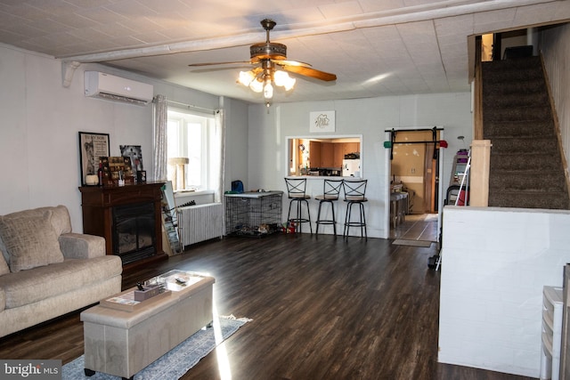 living room with dark hardwood / wood-style flooring, a wall mounted AC, and ceiling fan