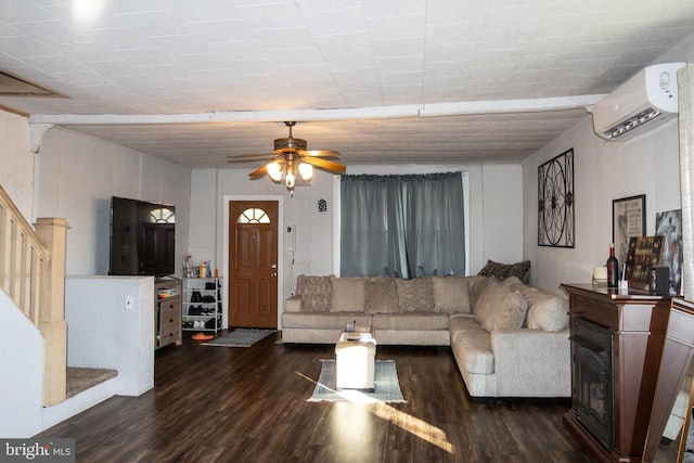 living room with a wall unit AC, ceiling fan, and dark wood-type flooring