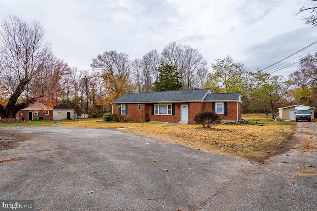 single story home featuring an outbuilding and a garage