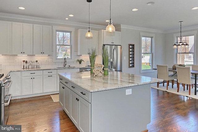 kitchen with white cabinets, appliances with stainless steel finishes, a center island, and dark hardwood / wood-style floors