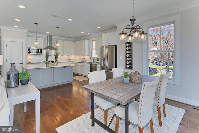 dining space featuring dark wood-type flooring, crown molding, and a healthy amount of sunlight