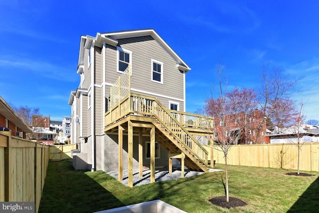 rear view of property featuring a wooden deck and a yard