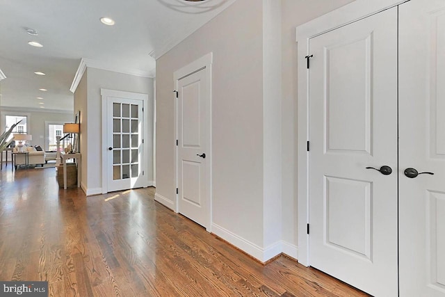 corridor featuring wood-type flooring and ornamental molding