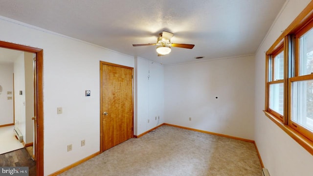 carpeted spare room with ceiling fan, ornamental molding, and a textured ceiling