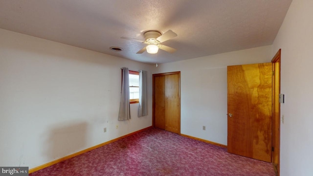 unfurnished bedroom with a textured ceiling, ceiling fan, light carpet, and a closet