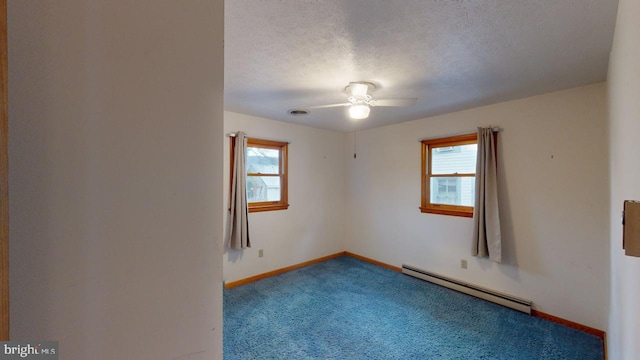 unfurnished room with a textured ceiling, carpet floors, ceiling fan, and a baseboard heating unit