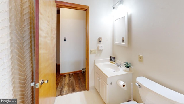 bathroom featuring toilet, vanity, and hardwood / wood-style flooring