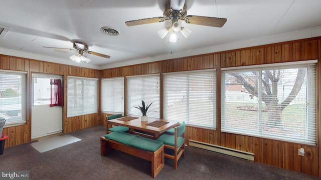 sunroom with a wealth of natural light, ceiling fan, and a baseboard heating unit