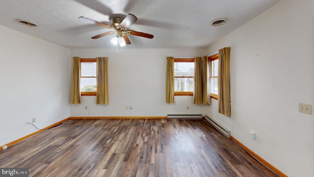 empty room with baseboard heating, plenty of natural light, and dark hardwood / wood-style floors