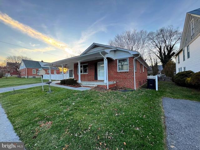 view of front facade with a lawn and covered porch