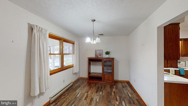 dining area featuring a textured ceiling, dark wood-type flooring, an inviting chandelier, and a baseboard heating unit