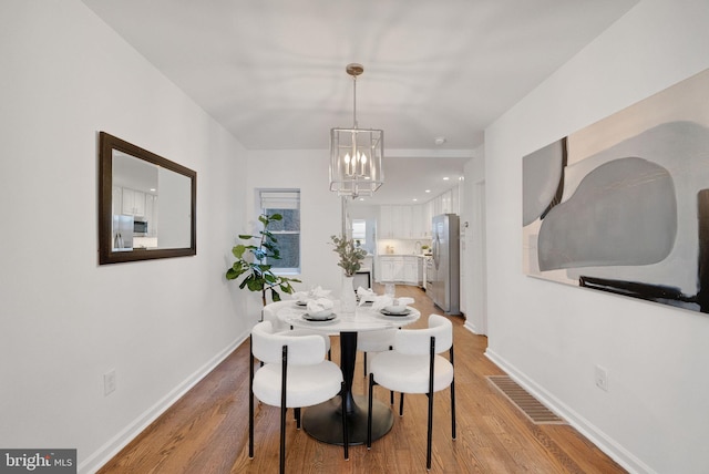 dining room featuring an inviting chandelier and light hardwood / wood-style flooring