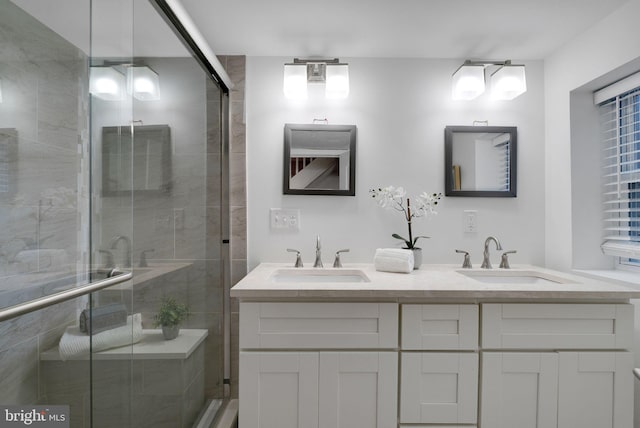 bathroom with a shower with door and vanity