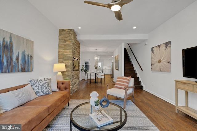 living room with dark hardwood / wood-style floors and ceiling fan with notable chandelier