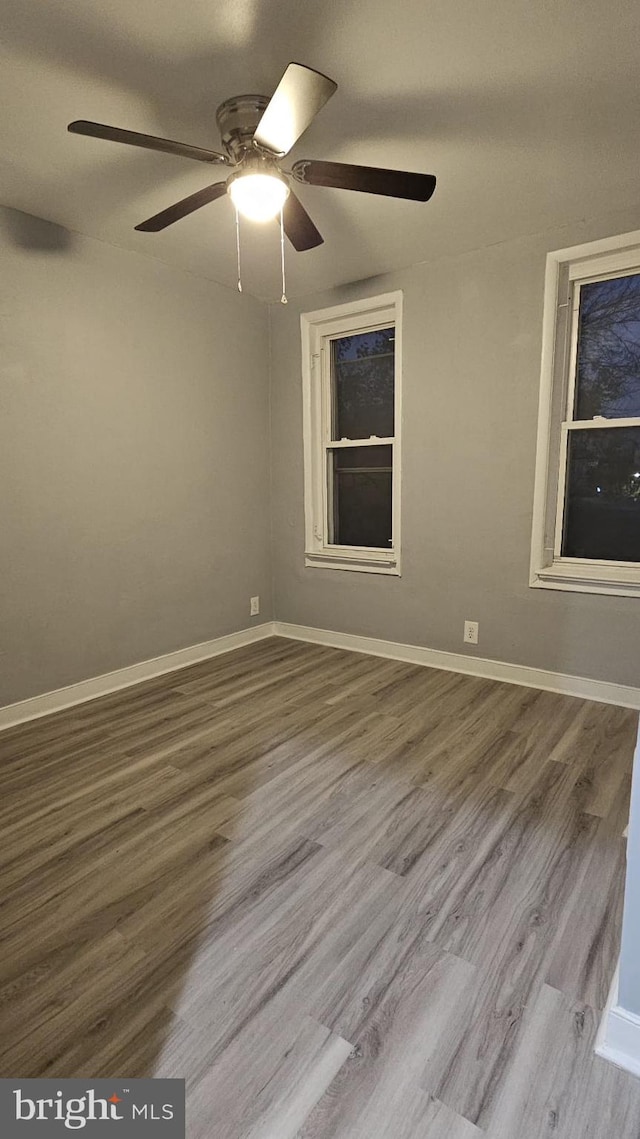 empty room with hardwood / wood-style flooring and ceiling fan