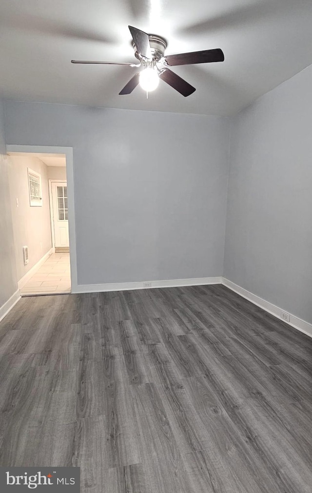 empty room with ceiling fan and dark wood-type flooring