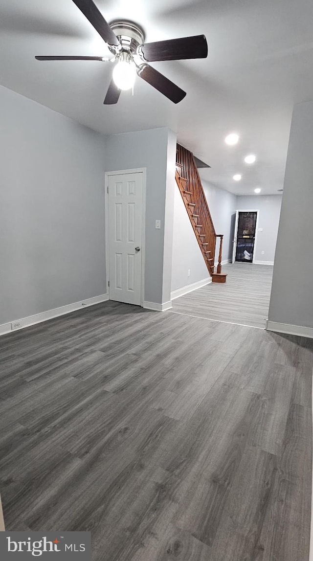 unfurnished room with ceiling fan and dark wood-type flooring