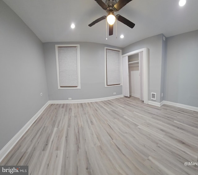 unfurnished bedroom featuring a closet, light hardwood / wood-style floors, vaulted ceiling, and ceiling fan