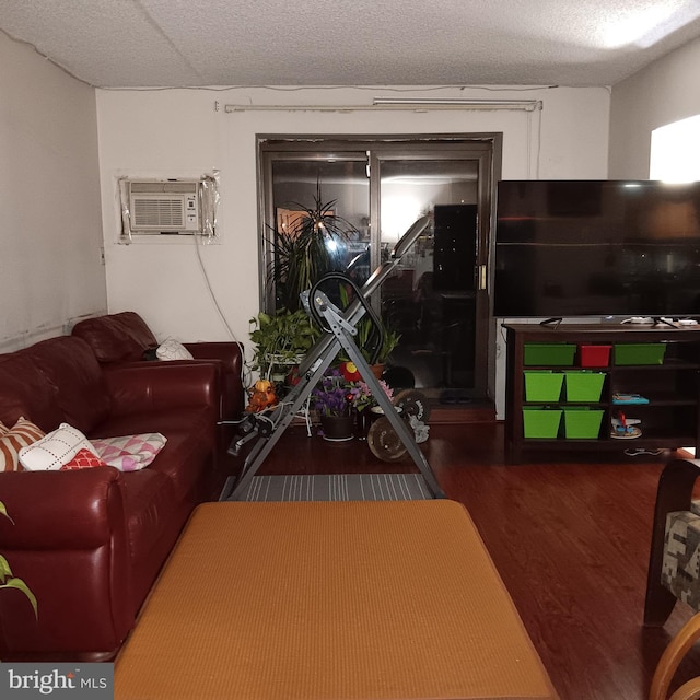 living room with a textured ceiling, dark wood-type flooring, and a wall mounted AC