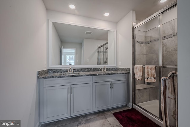 bathroom with tile patterned flooring, vanity, and an enclosed shower