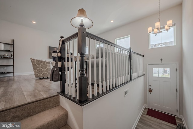 stairway featuring hardwood / wood-style floors and a notable chandelier