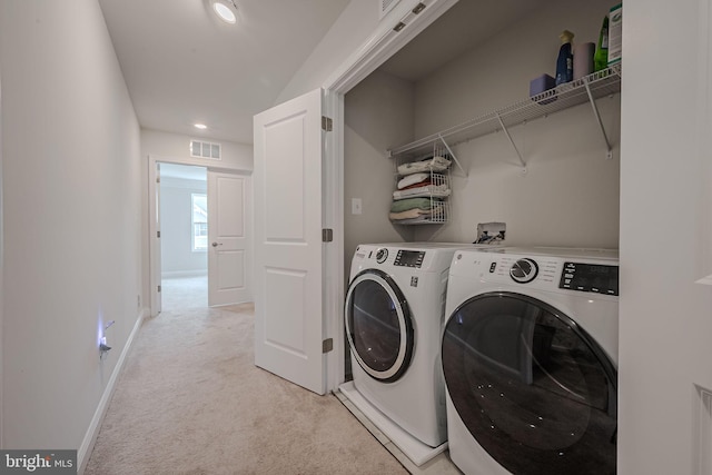 washroom with washing machine and dryer and light carpet