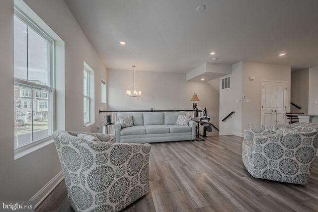 living room featuring light hardwood / wood-style floors and a notable chandelier