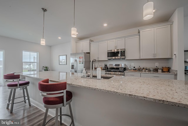 kitchen featuring white cabinets, sink, hanging light fixtures, dark hardwood / wood-style floors, and appliances with stainless steel finishes