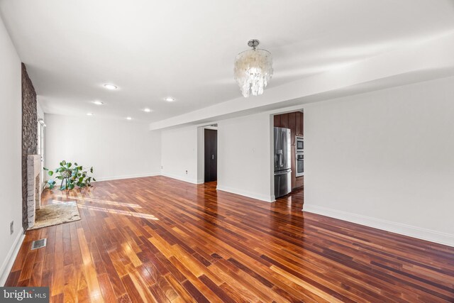 unfurnished living room with dark hardwood / wood-style flooring and a notable chandelier