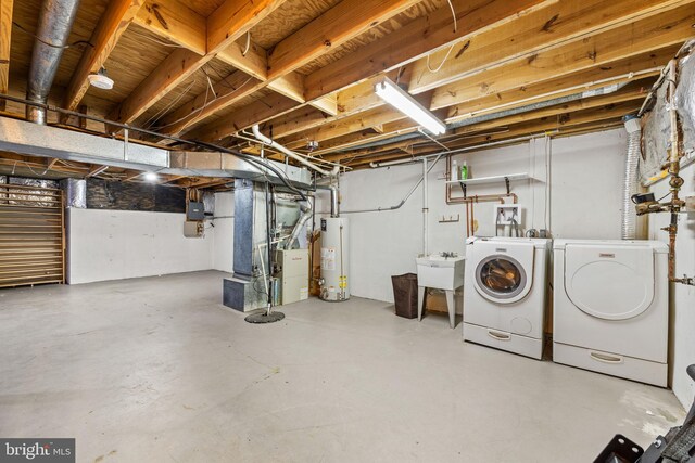 basement with sink, washing machine and dryer, water heater, electric panel, and heating unit