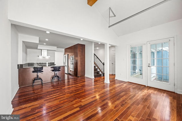 living room with beamed ceiling, high vaulted ceiling, and dark wood-type flooring