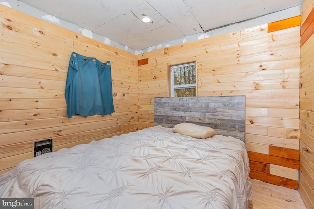 bedroom featuring wood walls and hardwood / wood-style floors