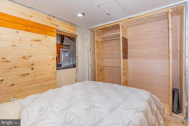 bedroom with a closet and wood walls