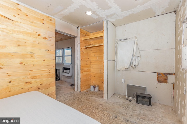 bedroom featuring wooden walls and heating unit