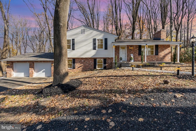 tri-level home with a porch and a garage