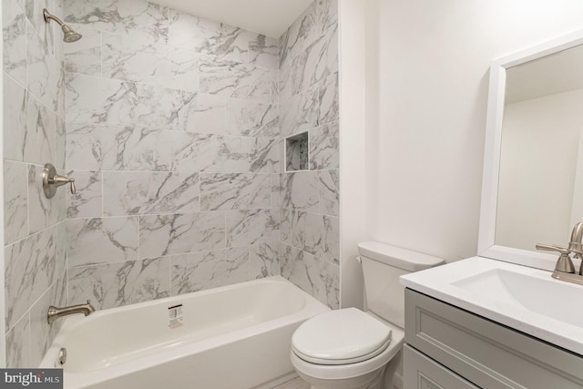 full bathroom with toilet, vanity, and tiled shower / bath