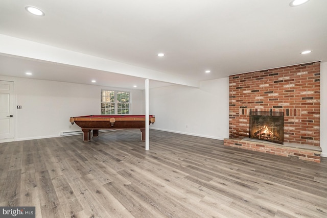 playroom featuring a fireplace, light wood-type flooring, a baseboard radiator, and billiards