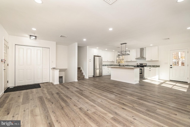 kitchen featuring white cabinetry, a kitchen island, light hardwood / wood-style floors, and appliances with stainless steel finishes