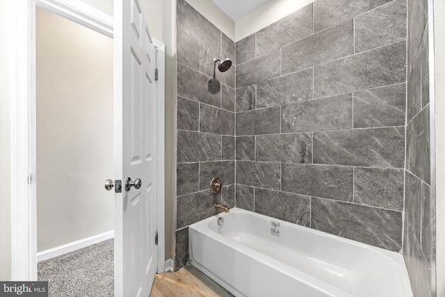 bathroom featuring wood-type flooring and tiled shower / bath combo