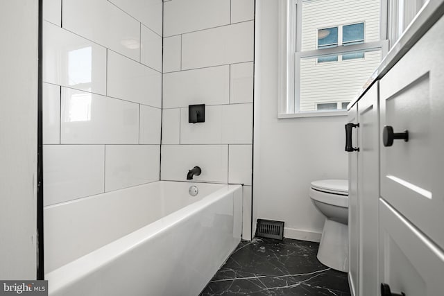 bathroom with tiled shower / bath combo and toilet