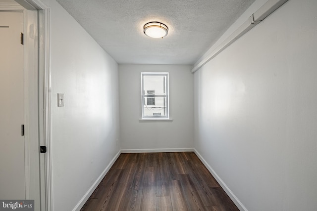 spare room with dark hardwood / wood-style floors and a textured ceiling