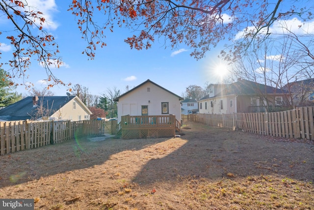 rear view of property featuring a yard and a wooden deck