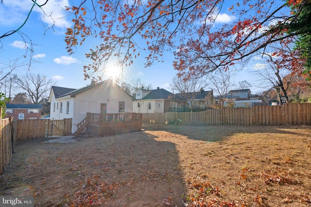 back of house featuring a yard and a wooden deck