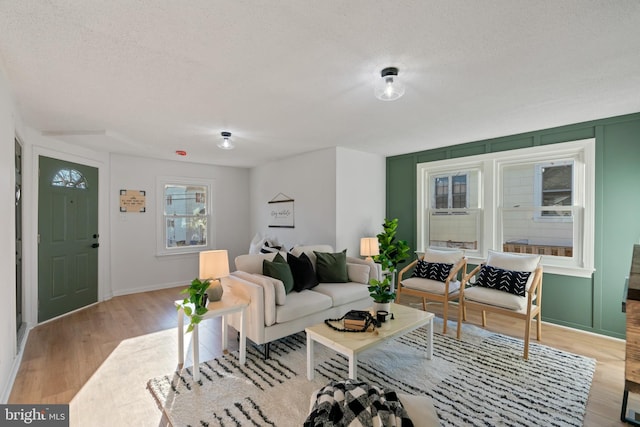 living room with light hardwood / wood-style floors and a textured ceiling