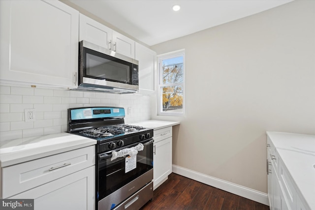 kitchen featuring light stone countertops, decorative backsplash, stainless steel appliances, dark wood-type flooring, and white cabinetry