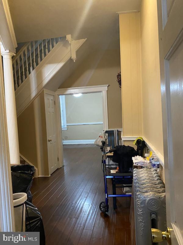 bonus room with dark hardwood / wood-style flooring and decorative columns