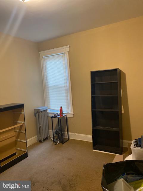 miscellaneous room with carpet flooring and radiator heating unit