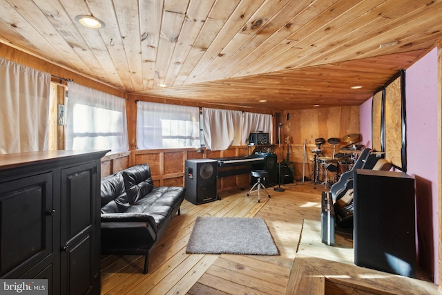 interior space with light wood-type flooring, wooden ceiling, wooden walls, and vaulted ceiling